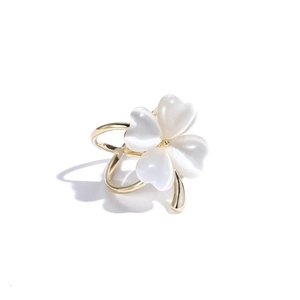 Bague trèfle doré avec pierres blanches en forme de cœur sur fond blanc épuré