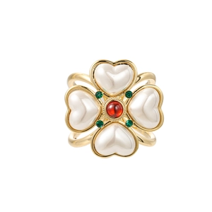 Vintage gold clover ring with heart-shaped pearls and a red gemstone center focal point