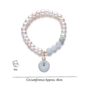 Freshwater pearl bracelet with a green jade donut charm and golden accents, 18cm length