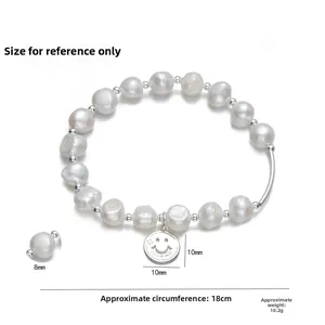 Detail of 8mm freshwater pearl bracelet with a silver smile pendant engraved with love me