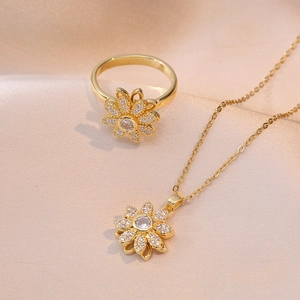 Elegantes rotierendes Blumen-Schmuckset mit Zirkonia auf champagnerfarbenem Seidenhintergrund