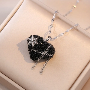 Collier cœur en zircon noir avec étoile argentée et chaînes à pompons dans son écrin
