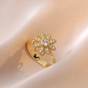 Elegante anello a fiore dorato con petali di zircone scintillanti su seta champagne