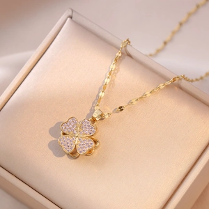 Macro shot of a four-leaf clover necklace with pink zircons and gold chain in a jewelry box
