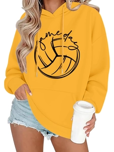 Close-up of yellow hoodie featuring black Game Day text and a volleyball graphic print