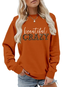Detail of orange crewneck sweatshirt featuring beautiful crazy leopard print pattern