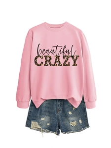 Detail of pink sweatshirt with leopard print text and distressed denim shorts