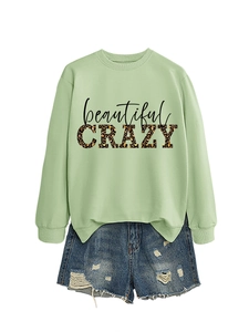 Detail of light green sweatshirt with leopard print CRAZY lettering and frayed denim shorts