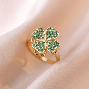 Adjustable rotating four-leaf clover ring with green zircons on pink silk fabric