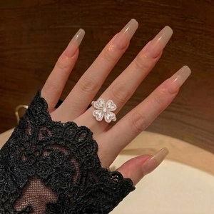 Eleganter rotierender Herzblumenring mit Zirkonia-Finish in Silber auf Spitzenhandschuh