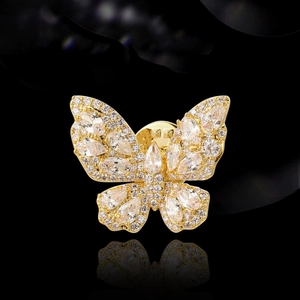 Elegant gold butterfly brooch with sparkling crystals on a reflective black background