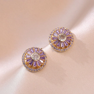 Rotating purple zircon flower stud earrings with a gold-plated base on silk background