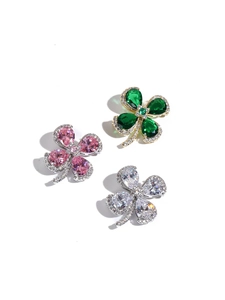 Detailed macro view of vintage emerald green clover brooches with water drop gemstones