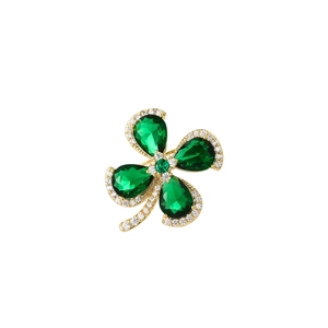 Detailed view of emerald green four-leaf clover brooch with sparkling pave crystals