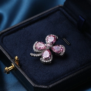 Pink pear-cut crystal clover brooch with silver-tone micro-pave setting on velvet