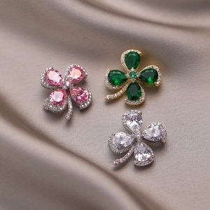 Vintage emerald and crystal four-leaf clover brooch in three colors on silk fabric