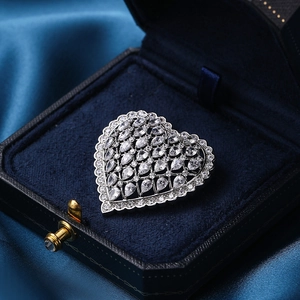 Elegant silver hollow heart brooch with sparkling crystals on dark blue velvet box