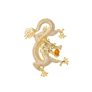 Macro shot of gold dragon brooch with micro-paved cubic zirconia and orange pearl detail