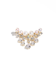 Macro detail of natural pearl and zircon brooch with sparkling tassel and gold finish