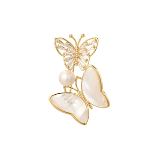 Detailed close-up of double butterfly brooch with natural shell and zircon accents