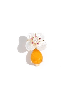 Detail of shell flower brooch with pearl center and hanging amber-colored gemstone