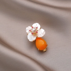 Elegant shell flower brooch with white pearl center and orange teardrop gemstone drop