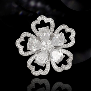Spilla a fiore in zircone con cristalli a goccia e petali a cuore su specchio nero lucido