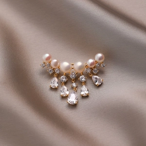 Elegant gold brooch with natural pearls and zircon tassel on champagne silk fabric