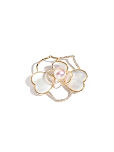 Detail van camelia broche met natuurlijke parelmoer bladeren en een centrale parel