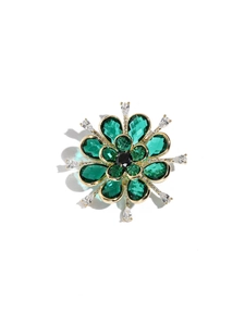Detail of emerald green flower brooch with zircon petals and golden metallic base