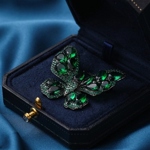 Vintage butterfly brooch with deep green crystals in a retro palace style setting