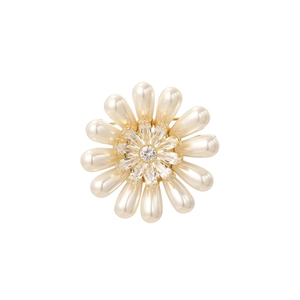 Détail macro d'une broche tournesol avec perles gouttes crème et cristal scintillant