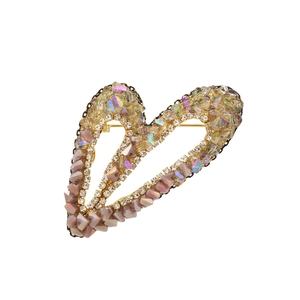 Détail d'une broche en forme de cœur avec cristaux de zircon rose et épingle dorée