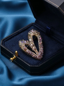 Détail d'une broche en forme de cœur avec cristaux colorés sur boîte en velours