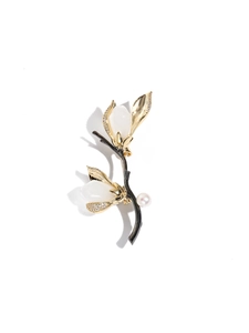 Détail d'une broche magnolia en jade Hetian avec accents de perles et strass