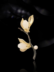 Détail de la broche magnolia avec pétales en jade blanc, bords dorés et une perle
