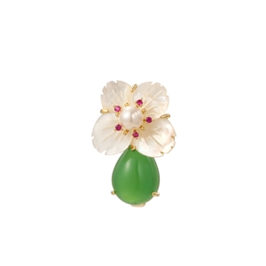 Detail of flower brooch with white shell petals, center pearl, and green teardrop gem