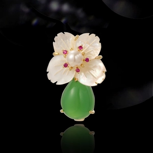 Vintage floral brooch with white shell petals, pearl center and green drop gemstone