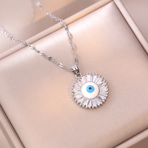 Collar de plata con colgante de ojo de girasol y circones en caja de joyas champán