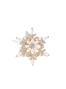 Detailed view of a rotating snowflake brooch with gold base, white pearls and crystals