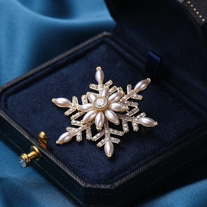 Rotating snowflake zircon brooch with pearls and rhinestones on deep blue velvet base