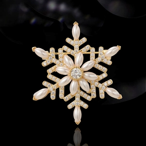 Elegant snowflake brooch with zircon and pearls on gold base with reflection