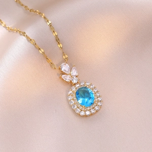 Collana dorata con ciondolo in zaffiro blu ovale e doppia fila di zirconi su seta