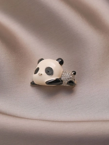 Close-up of cute giant panda brooch with sparkling crystals and enamel on silk