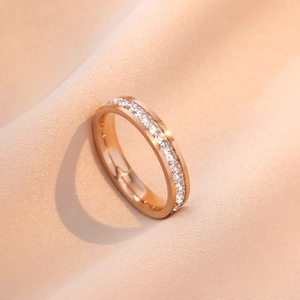 Bague en or rose avec cristaux carrés sertis sur tout le tour sur fond de satin