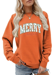 Close-up of ribbed crewneck and Christmas tree print on orange cotton sweatshirt