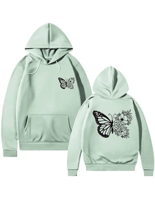 Détail d'un sweat à capuche vert clair avec motif papillon floral et poignets côtelés