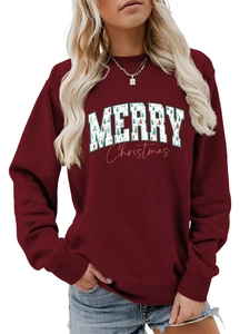 Close-up of a burgundy Christmas sweatshirt featuring festive tree-patterned lettering