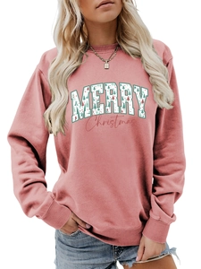 Close-up of women's pink sweatshirt featuring a festive Merry Christmas graphic print