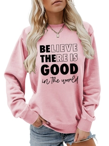 Dettaglio della felpa rosa con stampa tipografica nera 'BELIEVE THERE IS GOOD'